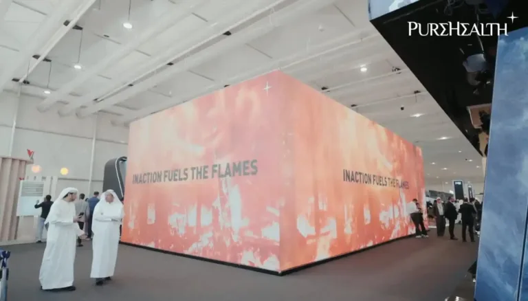 Several individuals standing together, focused on a screen LED displays information or visuals.