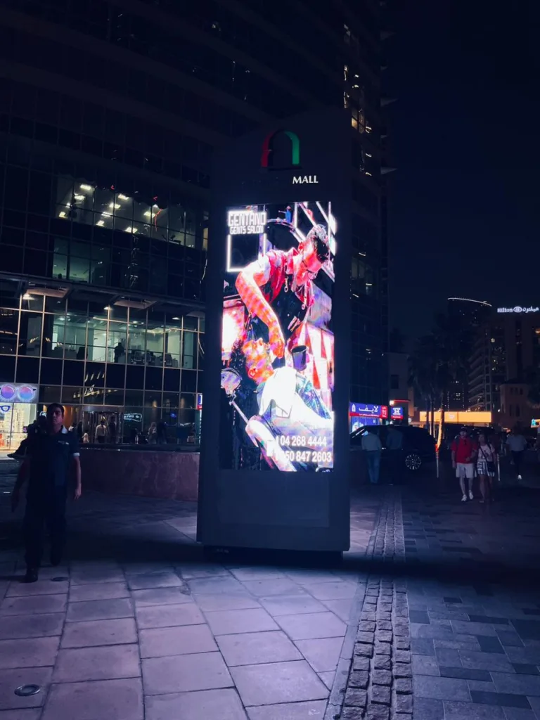 An outdoor LED screen glowing at night, providing a bright glow in the dark.