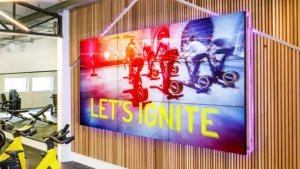 A vibrant gym scene with a Advertising display screens showcasing a group of people for Advertising screens outdoor and indoor.