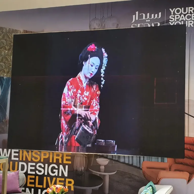 A store led display panel displaying a woman showcasing products.