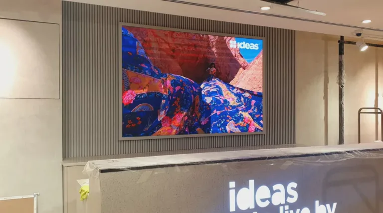 An indoor LED screen mounted on the wall displays vibrant content