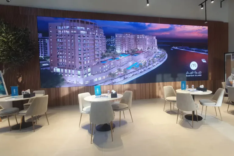 A large indoor led screen displays a beautiful beach view.