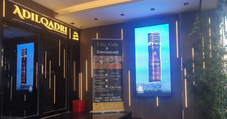 A hotel entrance featuring a led outdoor screen displaying visuals on the wall.
