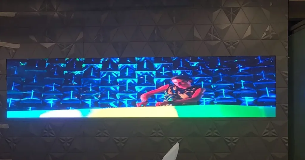 An LED video wall displaying a working man
