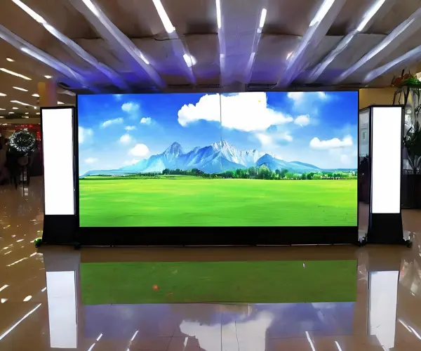 Bright LED screen indoor in a shopping mall, displaying colorful ads.