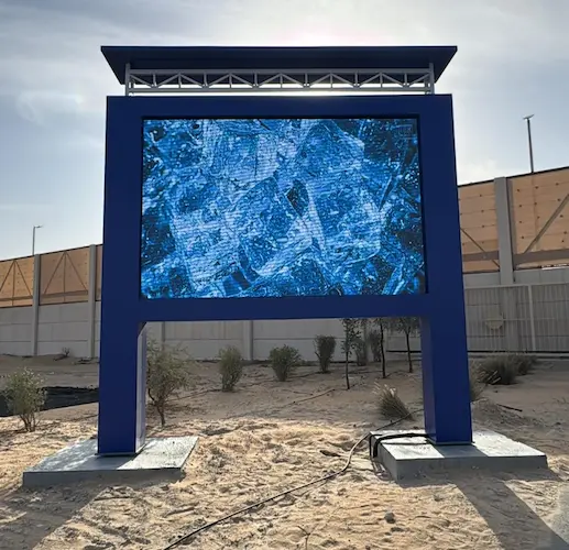An LED Screens outdoor stands in a desert landscape, displays blue ice scattered around.