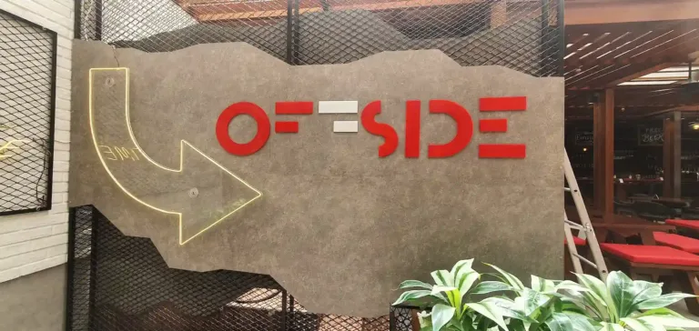 A vibrant 3D sign reading "Offside"