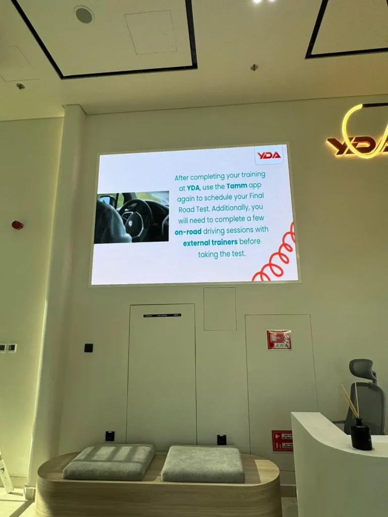 An LED screen indoors features a car, set in a stylish lobby.