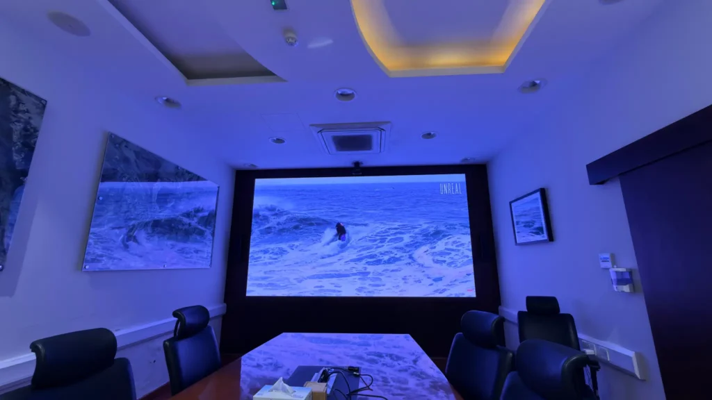 An indoor conference room with a large LED screen displayed on the wall for meetings.