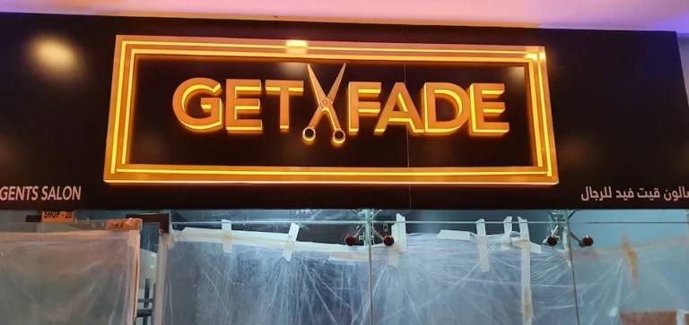 Neon sign in 3D style reading "get fade," against a dark backdrop.
