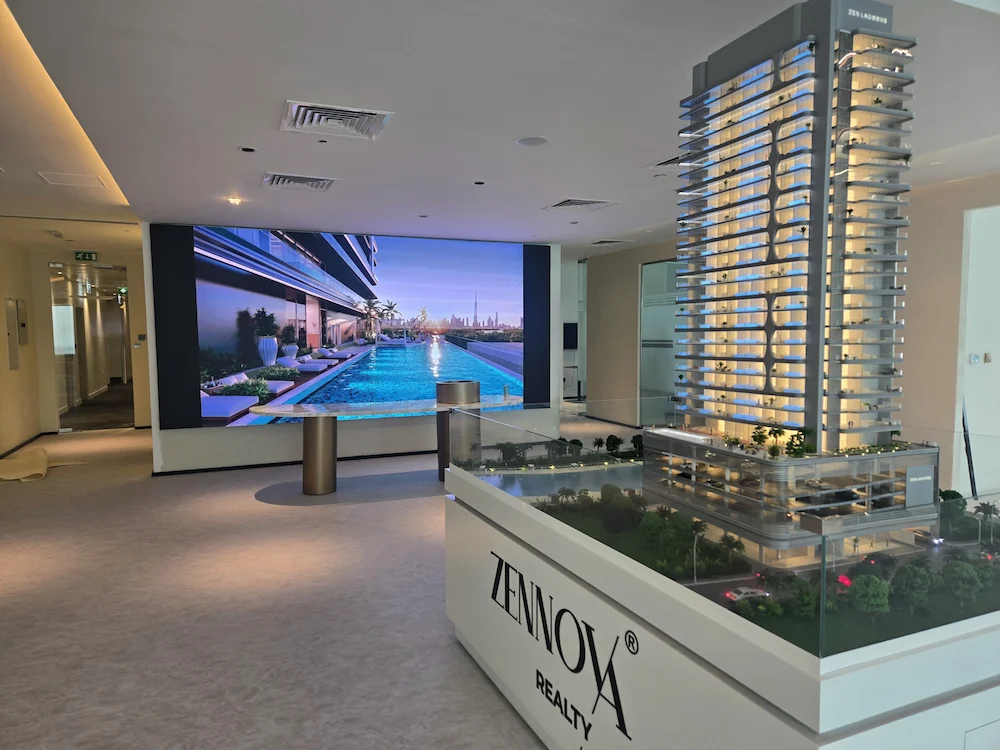 Architectural model showcased in a lobby, with an LED display screen