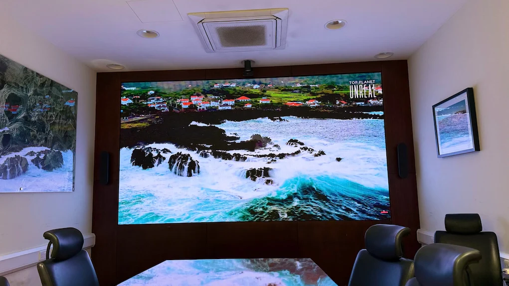 Large wall-mounted screen in a meeting room.