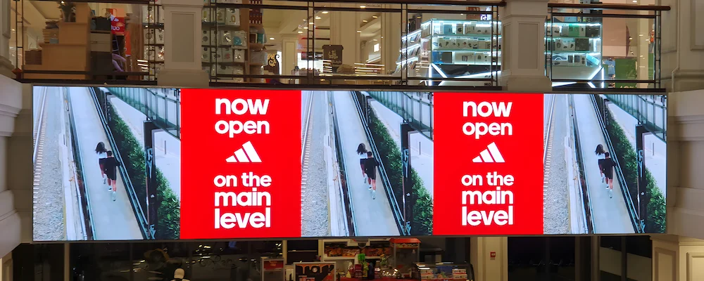 Large mall LED screen displays a man walking on a city street.