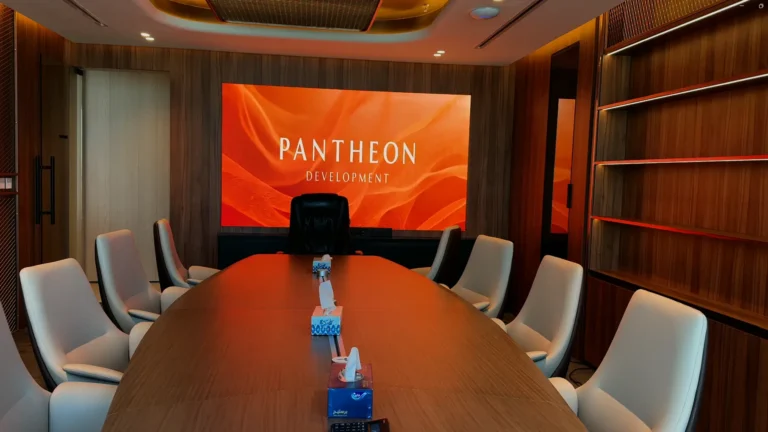 An LED screen and several chairs arranged in a meeting room.