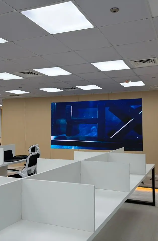 image shows an office with digital signage screen displaying some images