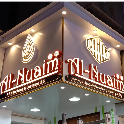 red and gold 3D letters for Al-Nuaim perfumes on a corner storefront