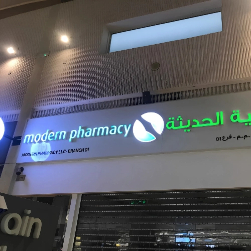 Illuminated 3D English and Arabic letters with a round logo for Modern Pharmacy