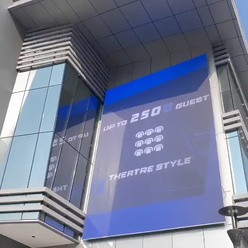 outdoor LED video display on a building facade, showing theatre-style seating capacity