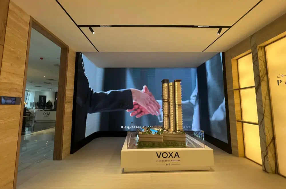 L-shaped corner flexible LED screen in a real estate showroom displaying video