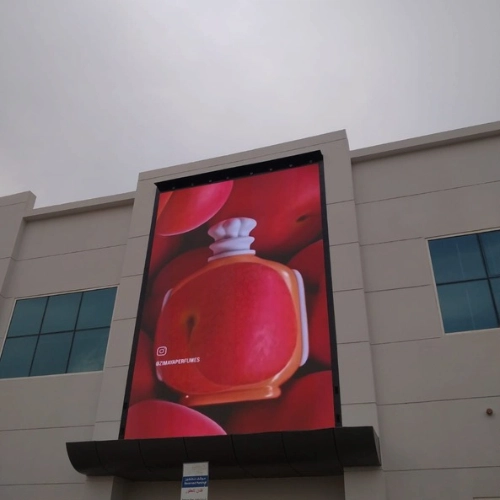 Vertical outdoor digital signage screen mounted on a commercial building facade