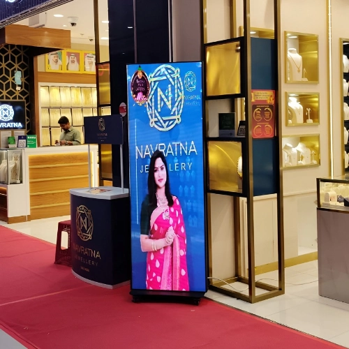Portrait digital display screen showing a jewellery advertisement inside a retail store