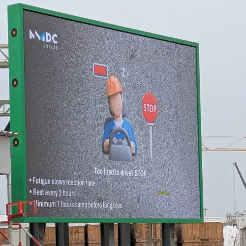 Large outdoor LED billboard showing a driver fatigue safety message