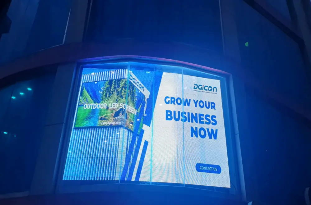 Curved transparent LED screen on a building glass facade at night