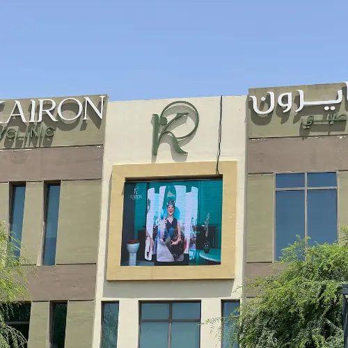 Outdoor LED screen in a framed opening mounted on a clinic building facade